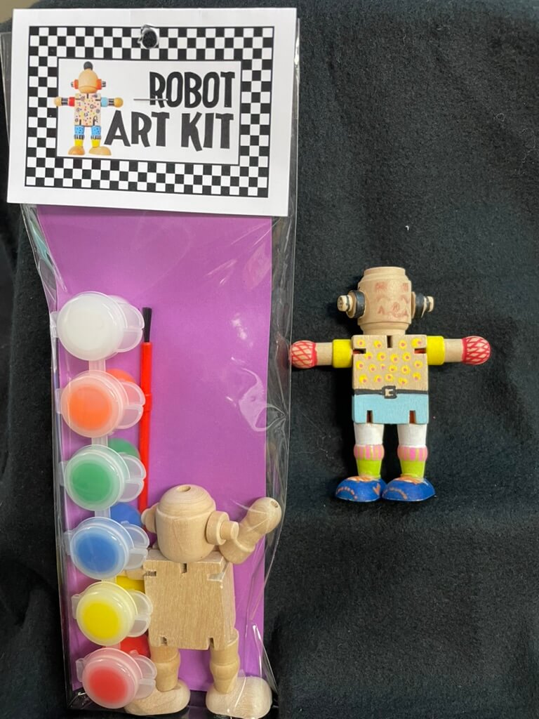The image shows a 'Robot Art Kit' packaging with a wooden figure of a robot and various colorful accessories like eyes, hats, and gloves.