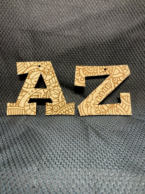 Wooden letters 'A' and 'Z' with intricate patterns on a textured gray background