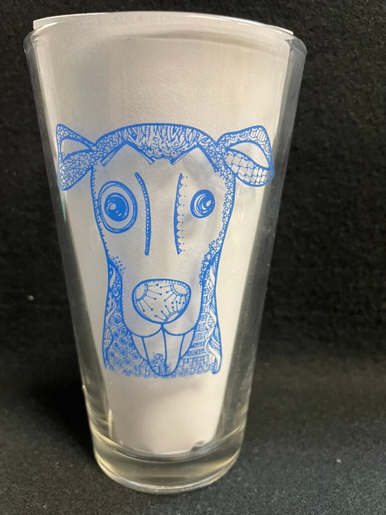 Pint glass with a dog drawing in blue
