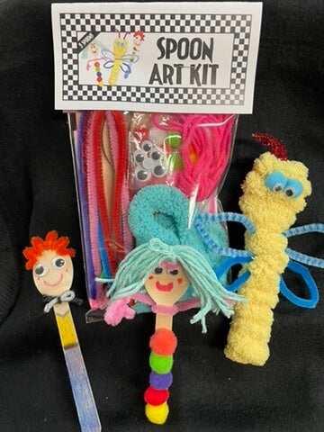 A plastic art kit called 'Spoon Art Kit' with various colorful crafting materials such as yarn, fabric, and beads, and a few plastic crafting tools like a spoon and a brush.