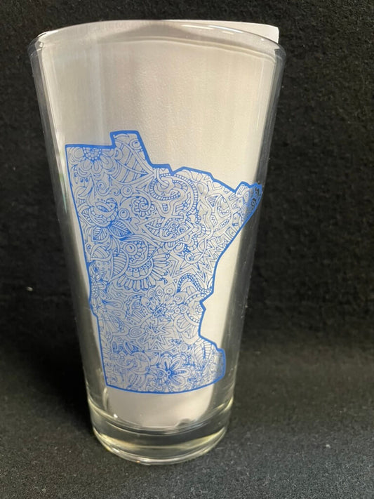 A clear pint glass with a blue map of Minnesota design.